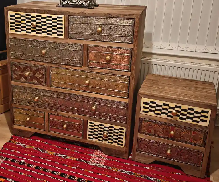 a large, ornate wooden dresser with multiple drawers featuring intricate inlays and patterns, including black-and-white…