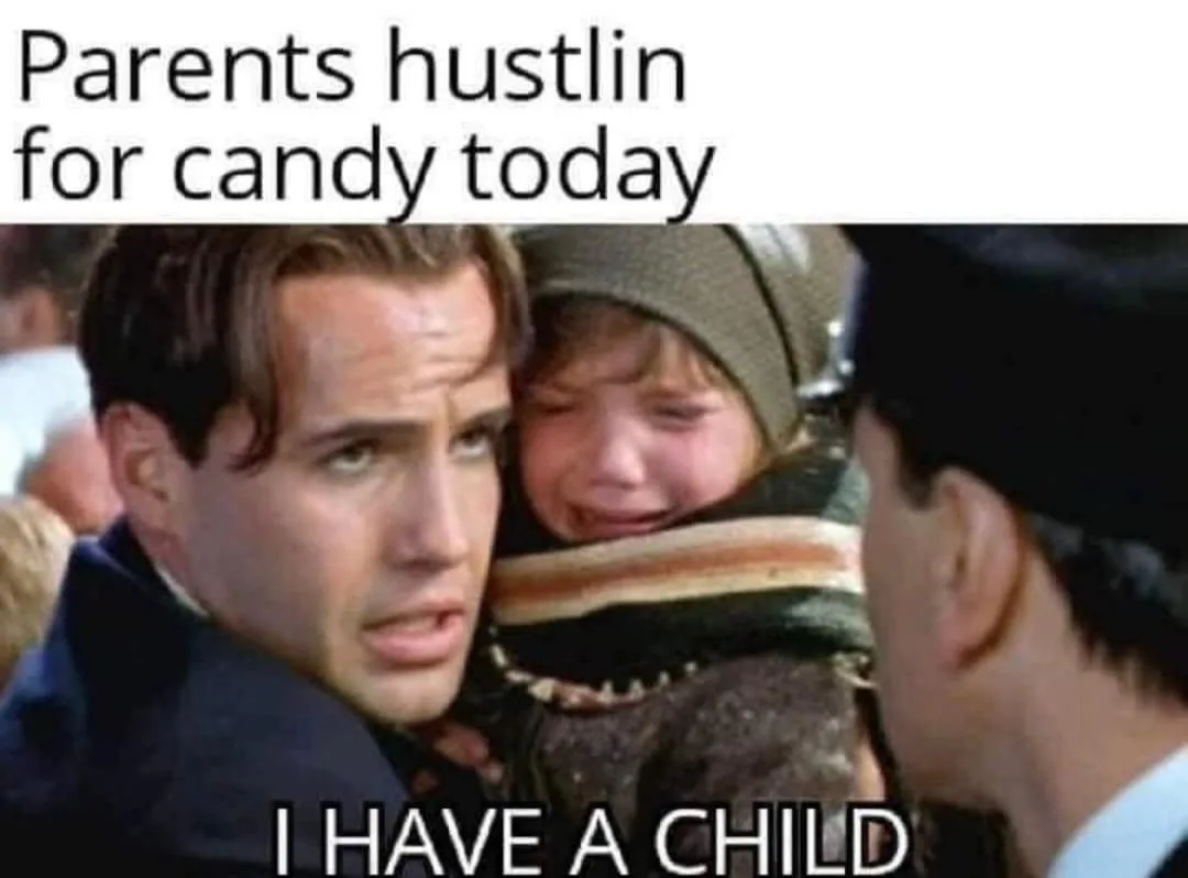 A man in a dark coat holds a crying child wearing a striped scarf and beanie, looking distressed while facing another person…