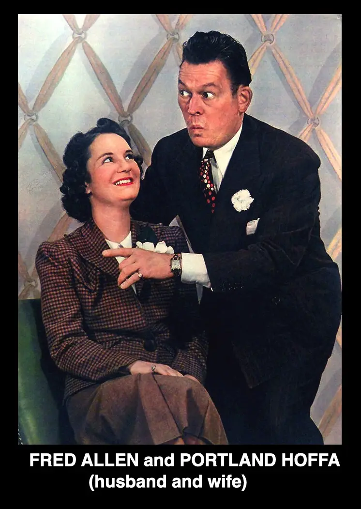 A vintage photo shows a man in a dark suit with a white flower lapel pin and patterned tie standing behind a seated woman in…