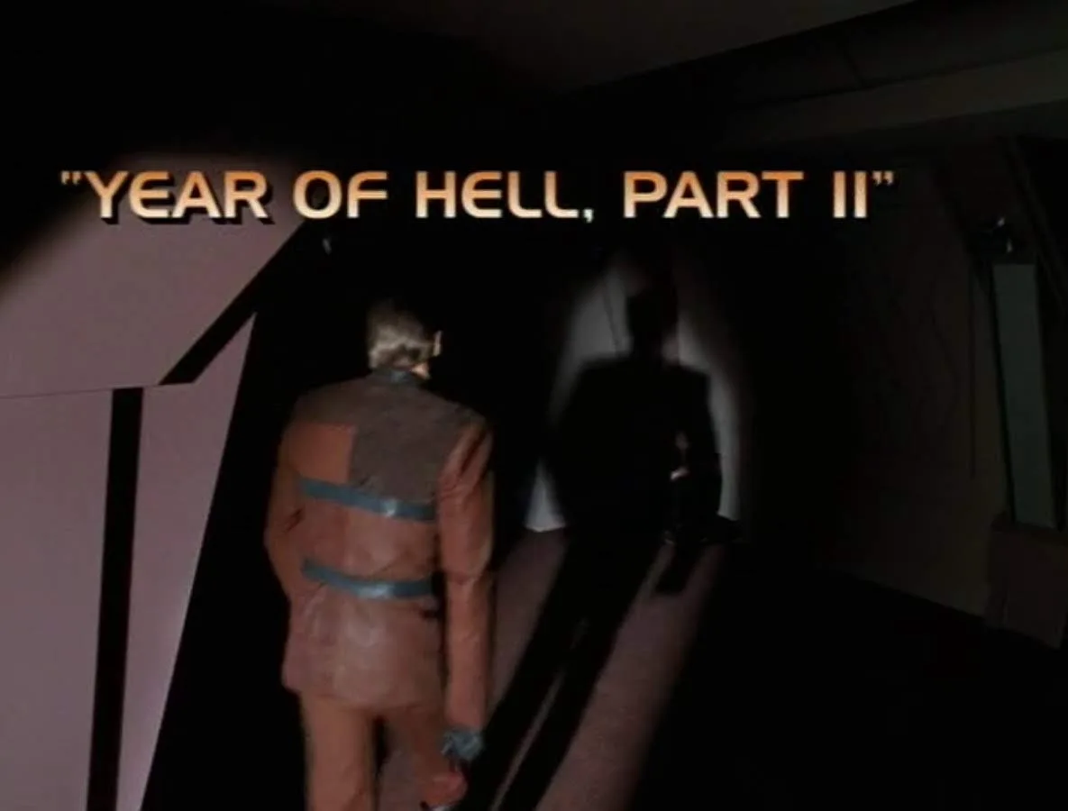 A person in a brown uniform with blue straps walks away from the camera down a dark corridor, casting a long shadow. The…