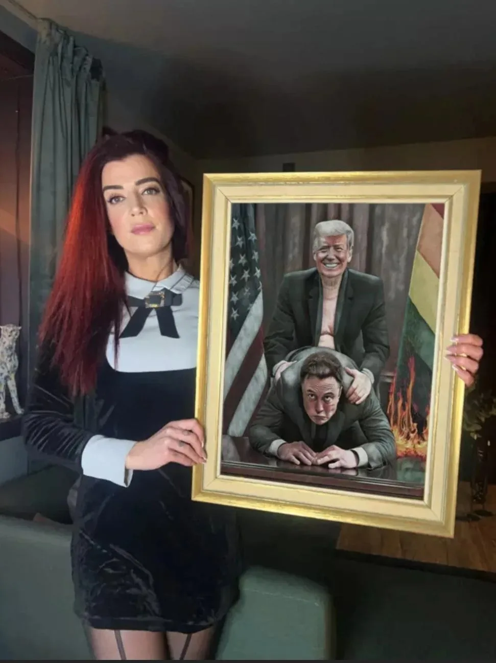 A woman with red hair and a black velvet dress holds a framed painting depicting Donald Trump standing behind Elon Musk with…