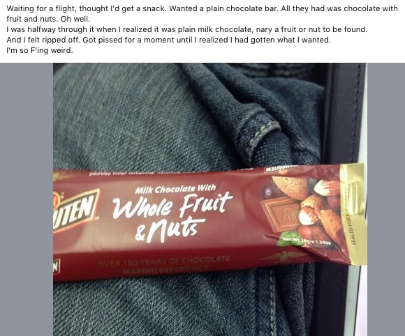 A close-up photo shows a red-wrapped 'Kitten' brand chocolate bar labeled 'Milk Chocolate With Whole Fruit & Nuts' resting…