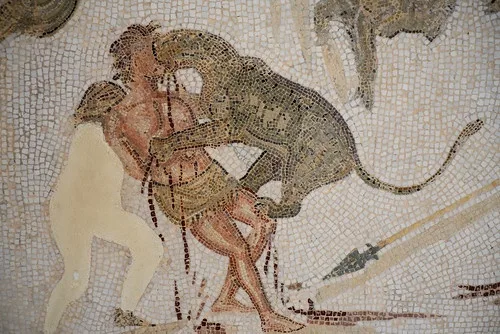 a mosaic depicts a man being attacked by a leopard while another man watches, with overlaid text reading 'a man is being…