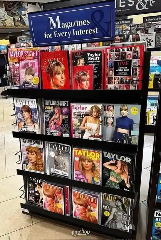 A magazine rack in a store is filled with numerous magazines, all featuring Taylor Swift on the cover, directly…
