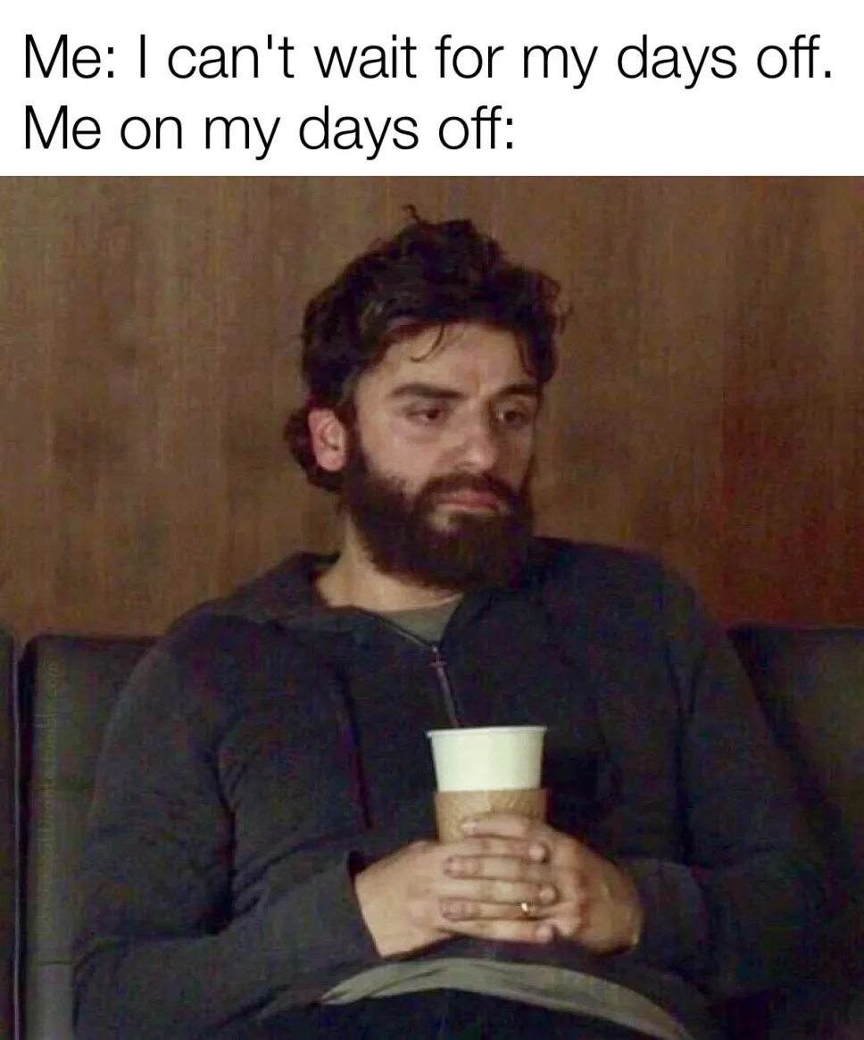 A man with a beard and dark hair sits on a couch holding a coffee cup, looking bored and unenthusiastic. The text above him…
