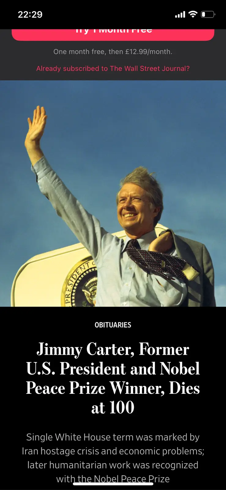 A screenshot of a Wall Street Journal obituary for Jimmy Carter, showing him smiling and waving while adjusting his tie. The…