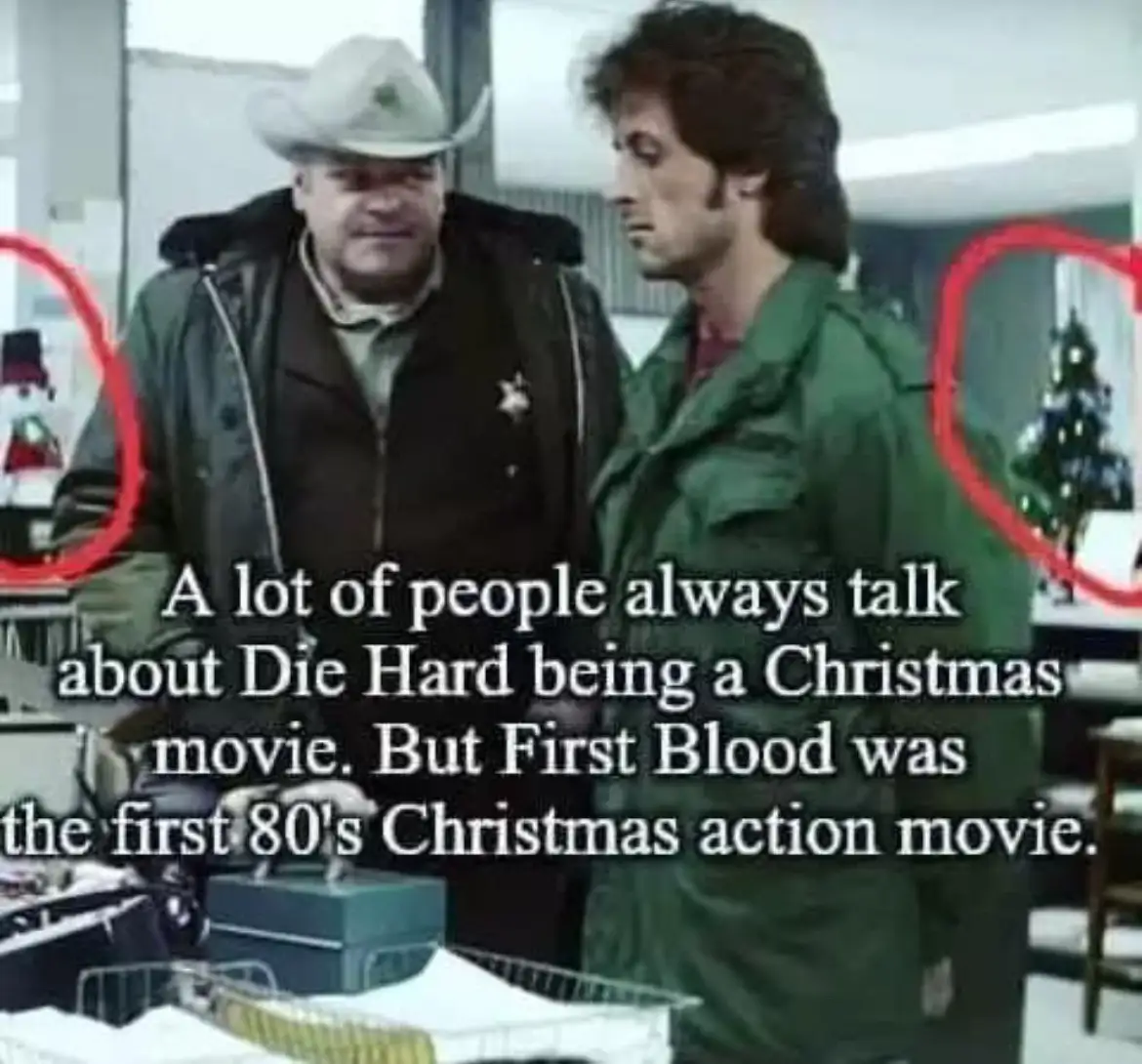 Two men stand in a room with a snowman and a Christmas tree circled in red on either side. The man on the left wears a…