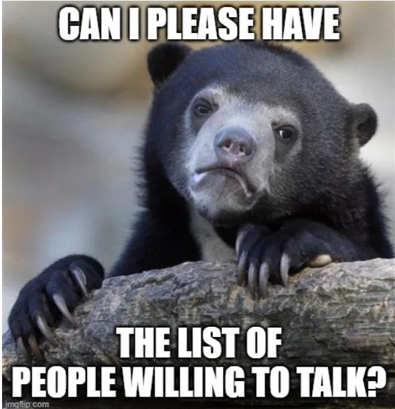 A black bear with a sad, pleading expression rests its paws on a log. White bold text overlaid at the top reads 'CAN I…