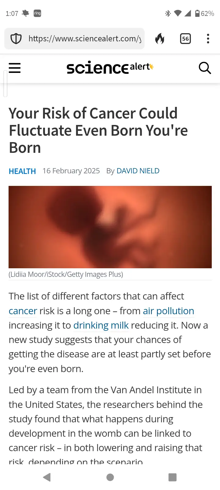 A screenshot of a ScienceAlert article titled 'Your Risk of Cancer Could Fluctuate Even Born You're Born' shows a blurry…