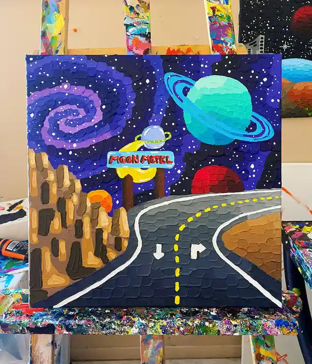 A textured, thickly painted canvas depicts a surreal desert highway leading to a motel sign that reads 'MOON MOTEL', set…