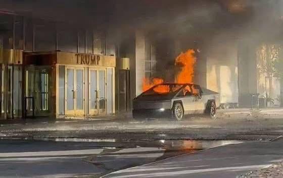 A Tesla Cybertruck is on fire in front of a building with a large 'TRUMP' sign above its entrance. The vehicle is engulfed…