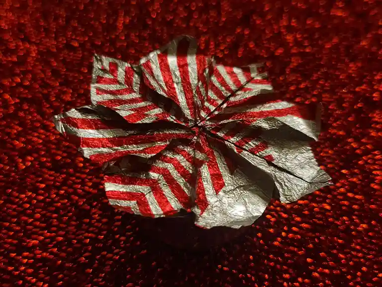 A crumpled, red-and-white striped Japanese flag lies on a textured red surface, with the overlaid text reading 'i'm not a…