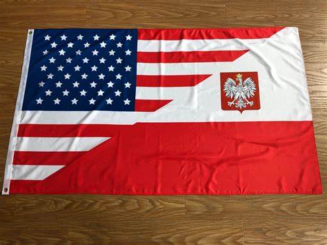 A flag laid flat on a wooden floor, combining the design of the American flag with the Polish coat of arms (a white eagle on…