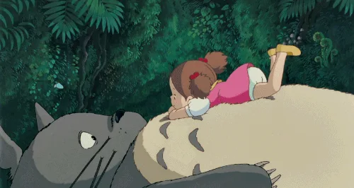 A sequence of six panels from the animated film 'My Neighbor Totoro' shows a young girl in a pink dress lying on the back of…