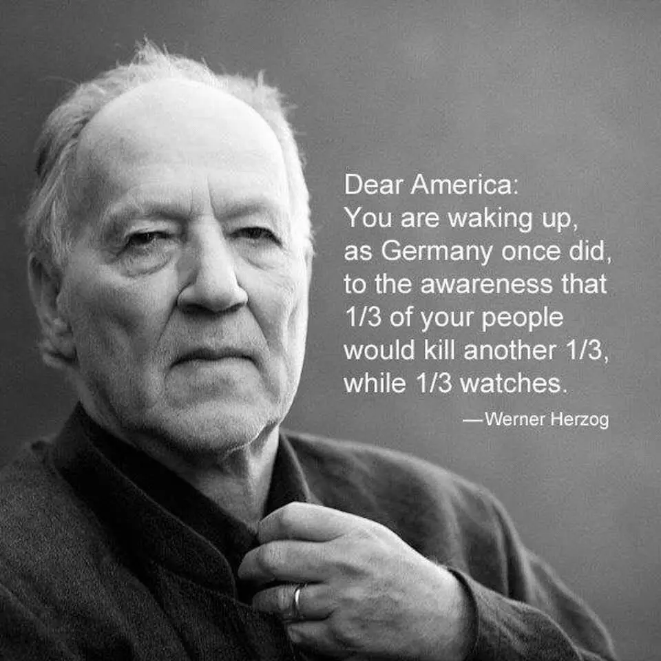 A black-and-white portrait of Werner Herzog, an older man with a serious expression, looking slightly off-camera while…