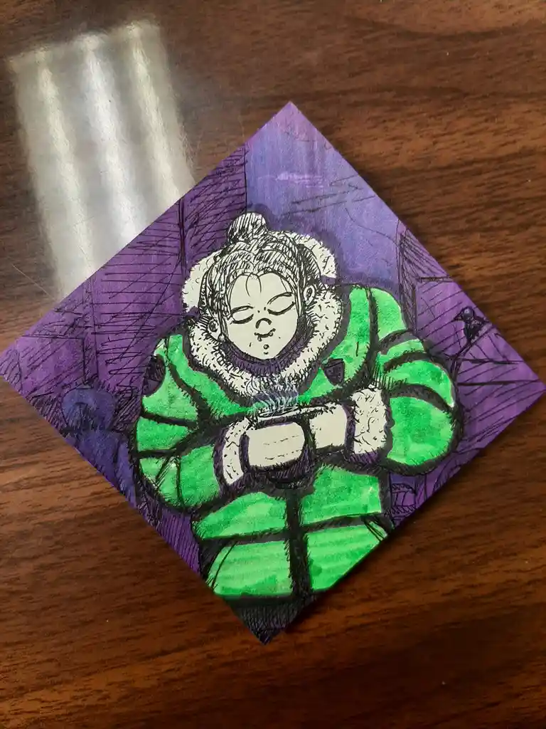 A hand-drawn illustration on a folded napkin depicts a person in a green puffy winter jacket with a white fur-lined hood…