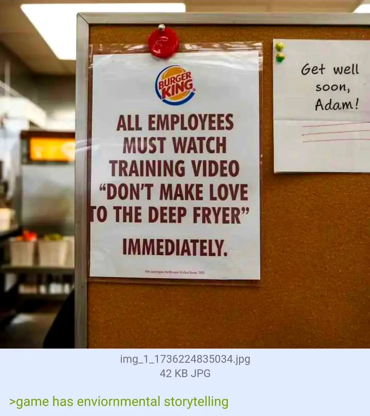 A Burger King training notice pinned to a corkboard in a restaurant kitchen, mandating all employees watch a video titled…