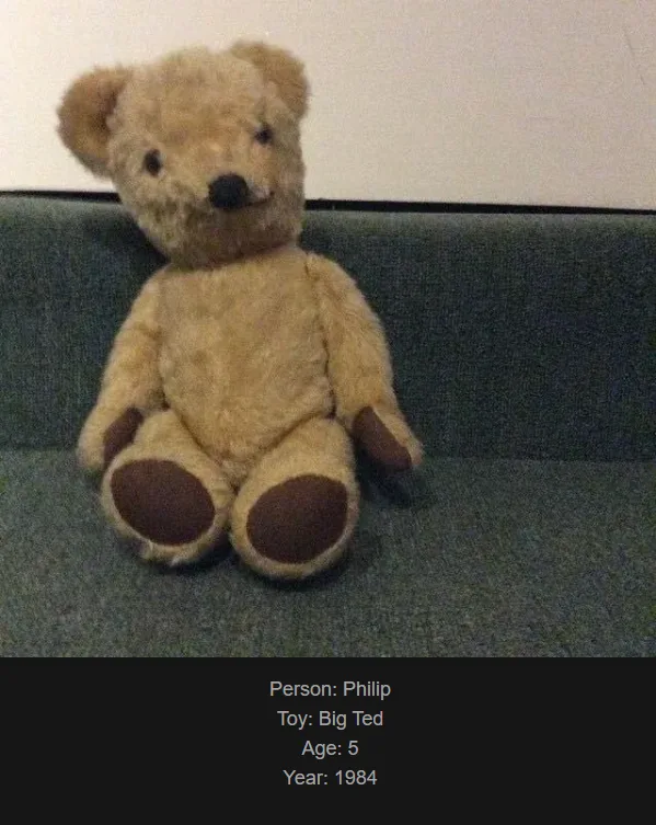 A beige, slightly worn teddy bear with dark brown paws and nose sits upright on a dark green couch. Text overlaid at the…