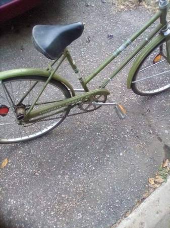 A green bicycle with a black seat is parked on a paved surface, with the overlaid text reading 'i'm not lazy i'm in energy…