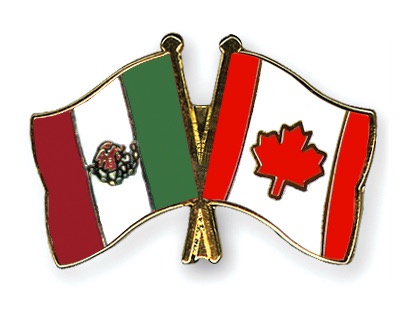 Two enamel flag pins, one of Mexico (green, white, red vertical stripes with coat of arms) and one of Canada (red vertical…