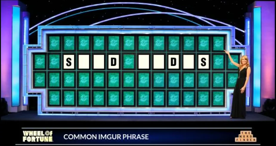 A woman in a black dress stands beside a large game board from Wheel of Fortune, which displays the letters S, D, S with…