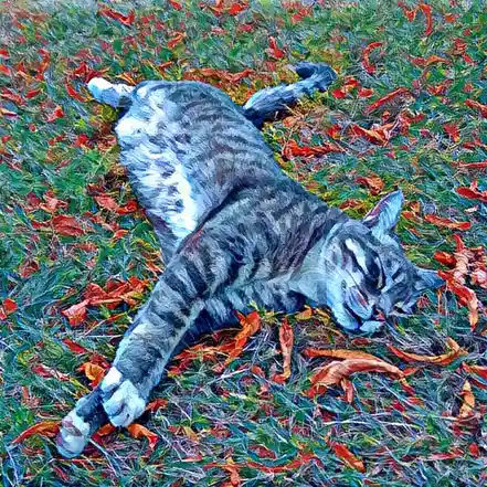 A tabby cat with white paws lies sprawled on its side in a grassy area scattered with red and orange autumn leaves…