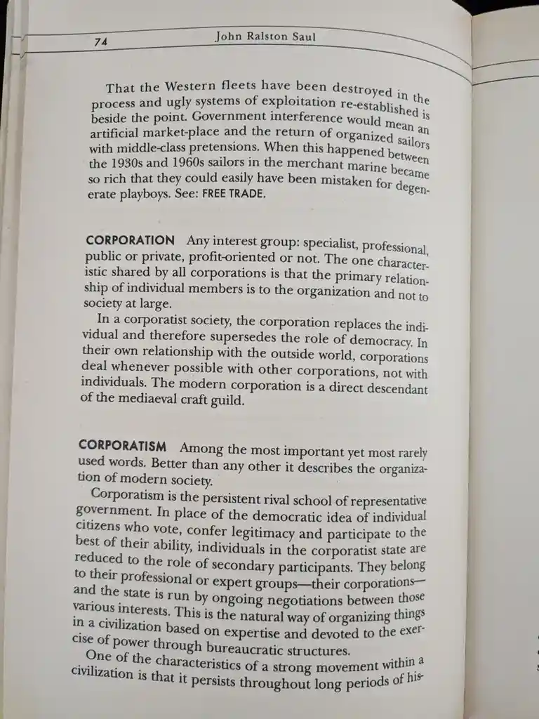 A close-up photo of page 74 from a book by John Ralston Saul, showing text defining 'CORPORATION' and 'CORPORATISM'. The…