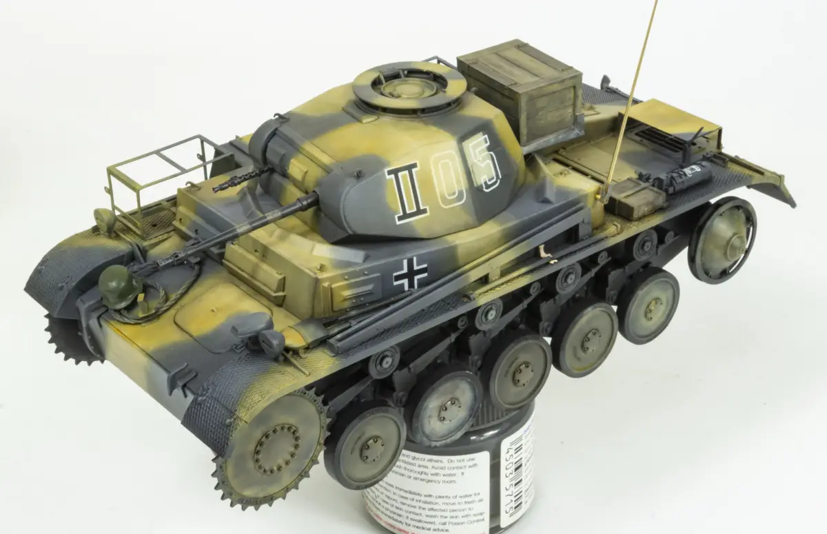 A detailed scale model of a German World War II tank, painted in camouflage with the markings 'II05' and a black cross, is…
