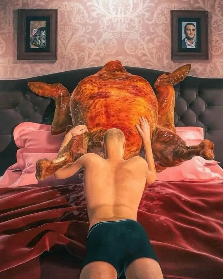 A shirtless man in dark underwear is seen from behind, kneeling on a bed with red satin sheets and pink pillows, gently…