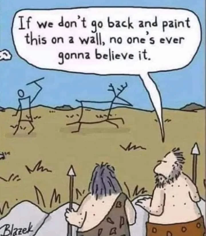 Two cavemen stand in a field, looking at stick-figure drawings of a person and a deer on the ground. One caveman speaks via…