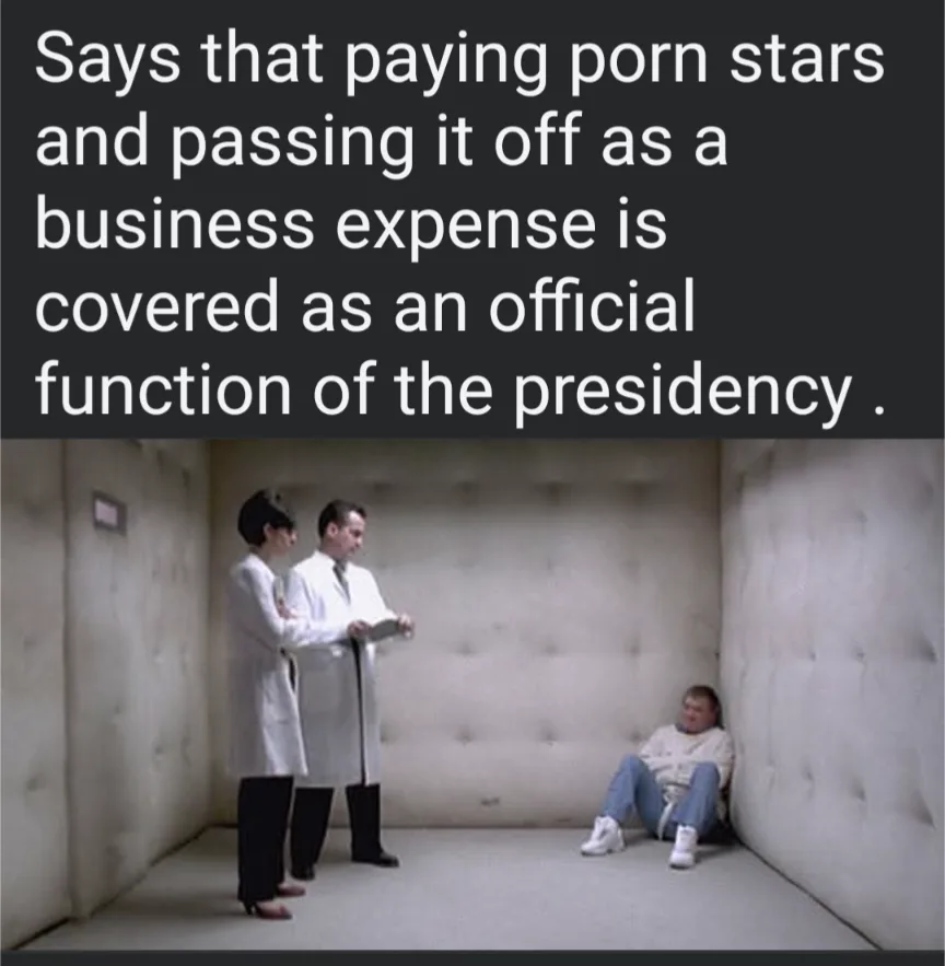 Two people in white lab coats stand over a seated person in a small, padded room. The overlaid text reads: 'Says that paying…