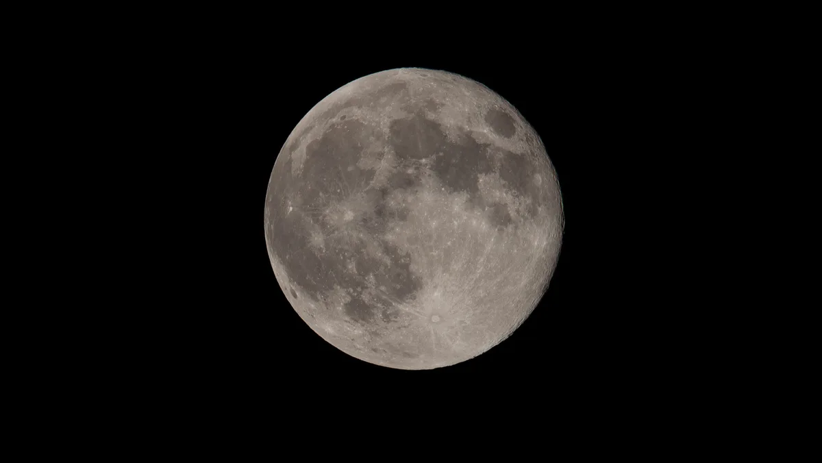 A high-resolution image of the full moon against a black sky, showing detailed craters and surface textures. Overlaid text…