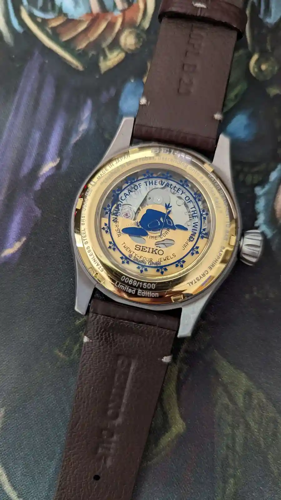 A close-up of the back of a Seiko watch, which is a limited edition collaboration with Studio Ghibli, featuring a blue…