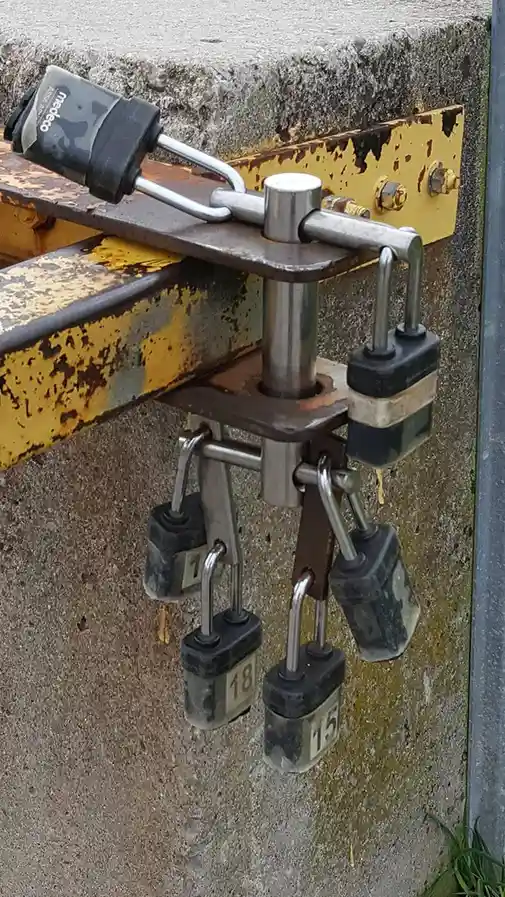 A heavy-duty metal hitch mechanism is secured with multiple heavy padlocks, including one labeled 'Medeo' and others…