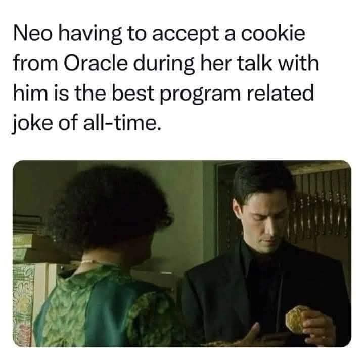 A still from 'The Matrix' shows Neo, in a black suit, reluctantly accepting a cookie from Oracle, who is facing him in a…