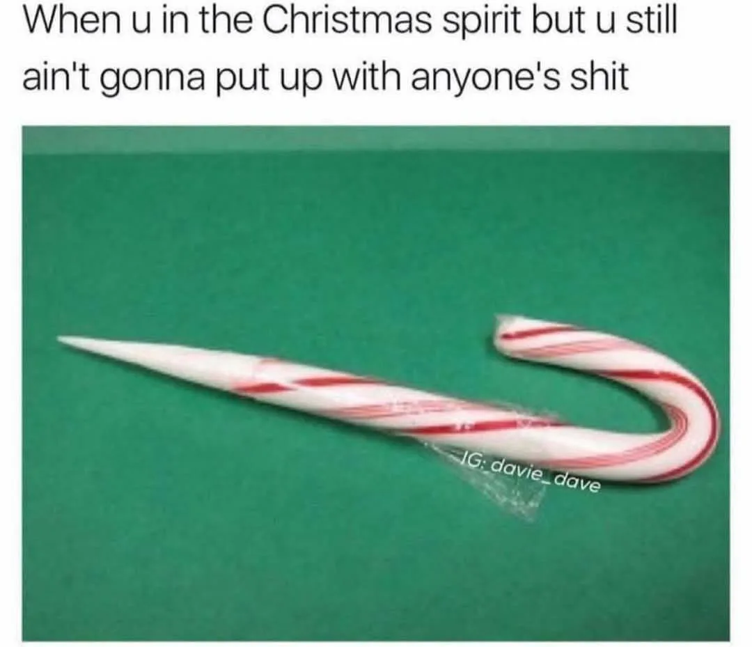 A candy cane with its curved end broken off and replaced with a sharp, pointed tip, lying on a green surface. The overlaid…
