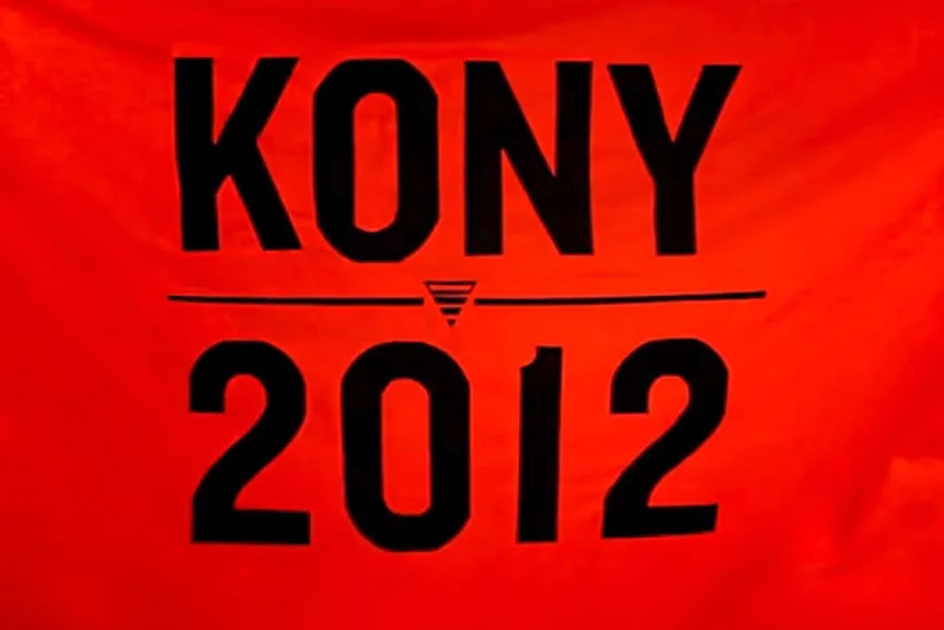 A close-up of a bright red fabric, likely a banner or t-shirt, with bold black text reading 'KONY' above a horizontal line…