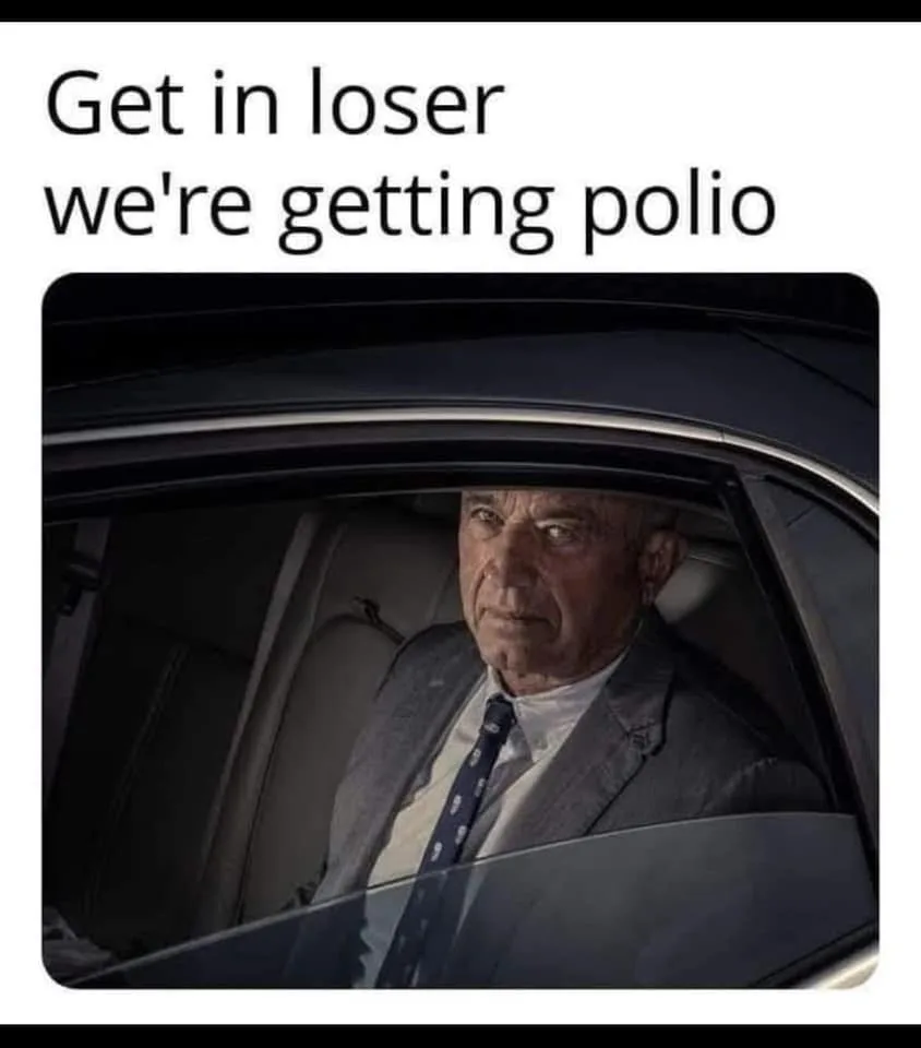 A man in a suit and tie sits in the back seat of a car, looking sternly at the camera. The text overlaid at the top reads…