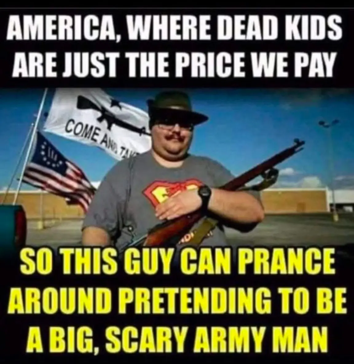 A man wearing a hat, sunglasses, and a Superman t-shirt holds a rifle while standing in front of an American flag and a…