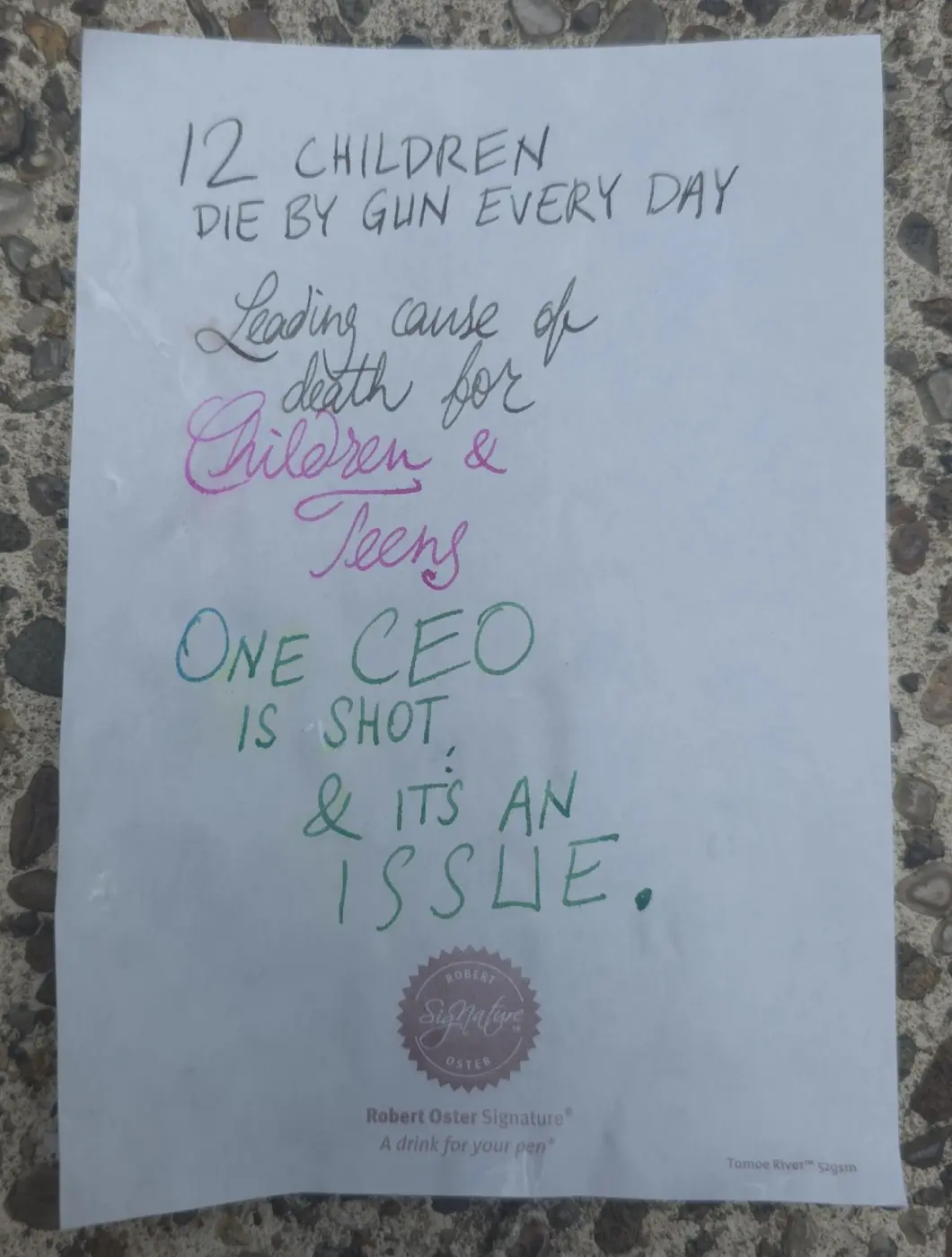 A handwritten note on a Robert Oster Signature pen pad states that 12 children die by gun every day, that it's the leading…