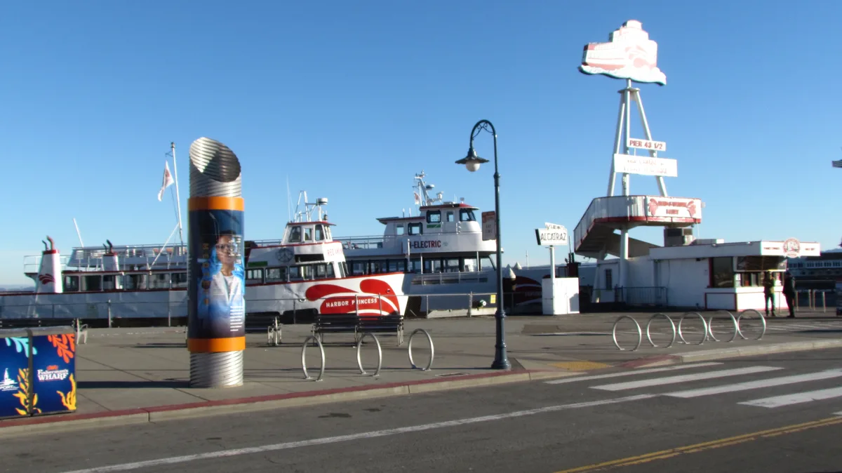 A daytime photo of Fisherman's Wharf in San Francisco shows a ferry named 'Harbor Princess' docked near a pier with a large…
