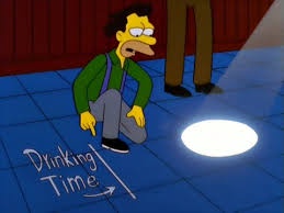 A cartoon man in a green vest and grey pants kneels on a blue tiled floor, pointing at a bright white spotlight on the…