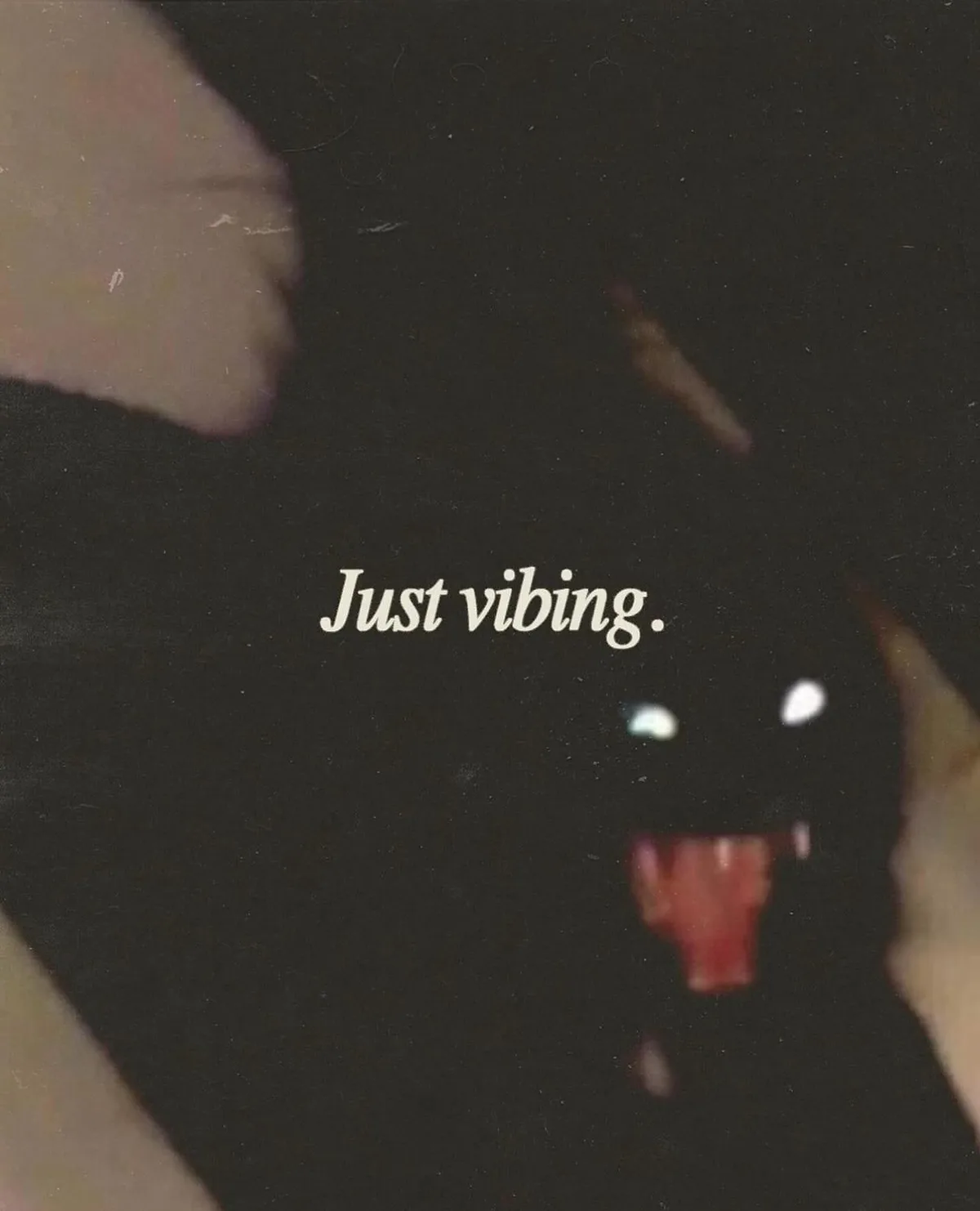 A blurry, low-light photo shows a person's face partially obscured by darkness, with glowing white eyes and a red tongue…