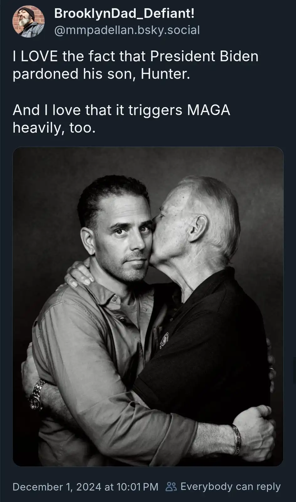 A black-and-white photo shows an older man kissing the cheek of a younger man while embracing him. The overlaid text…