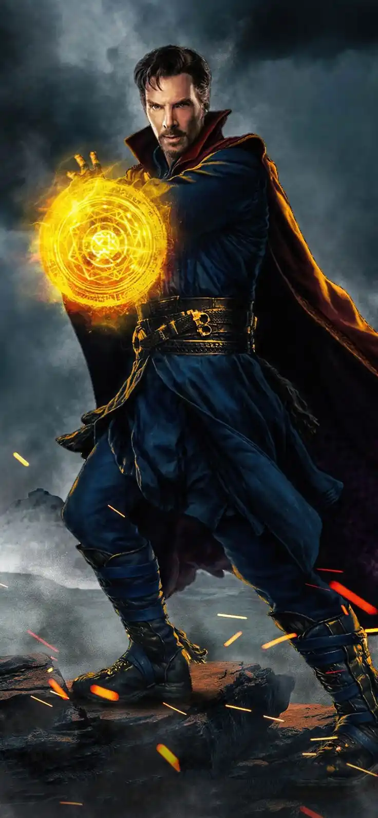 A man in a dark blue robe and red cape stands on rocky terrain, holding a glowing, intricate magical orb in his right hand…