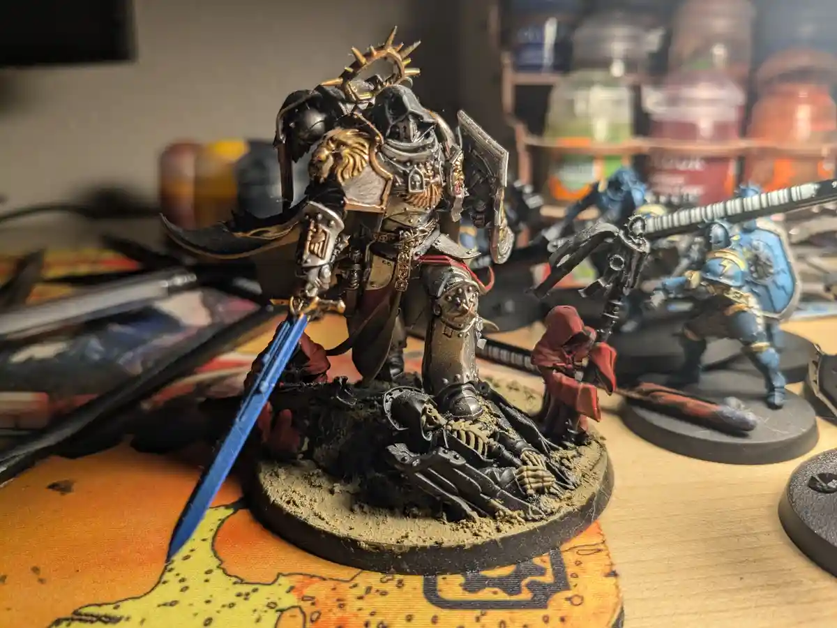 A heavily armored, ornate miniature warrior figure stands on a circular base with a painted pile of bones and skulls beneath…
