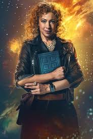 A woman with curly hair, wearing a black leather jacket and holding a blue police box, stands confidently against a cosmic…