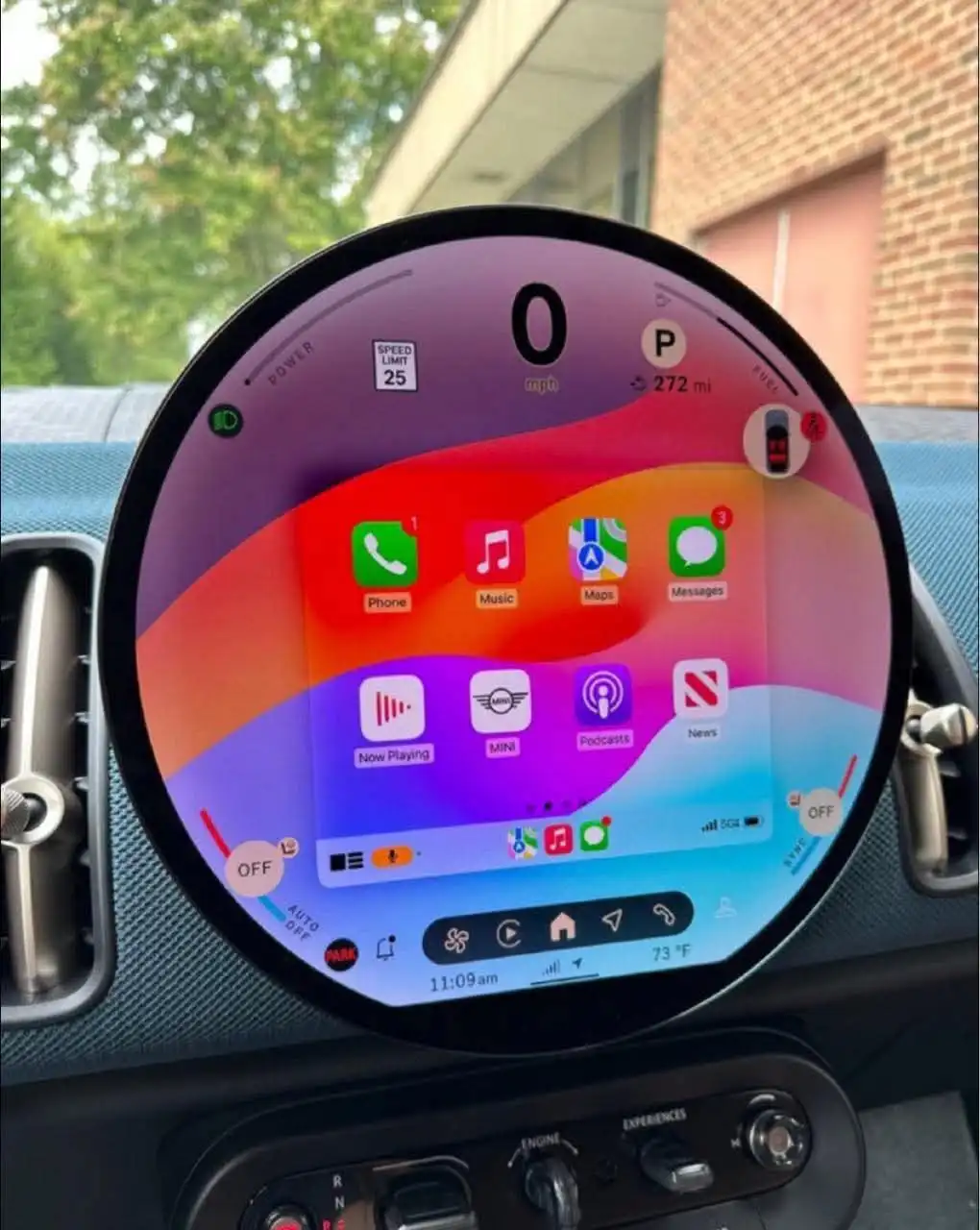 A close-up of a car's circular digital dashboard displaying a speed of 0 mph, with a speed limit indicator showing 25 mph…