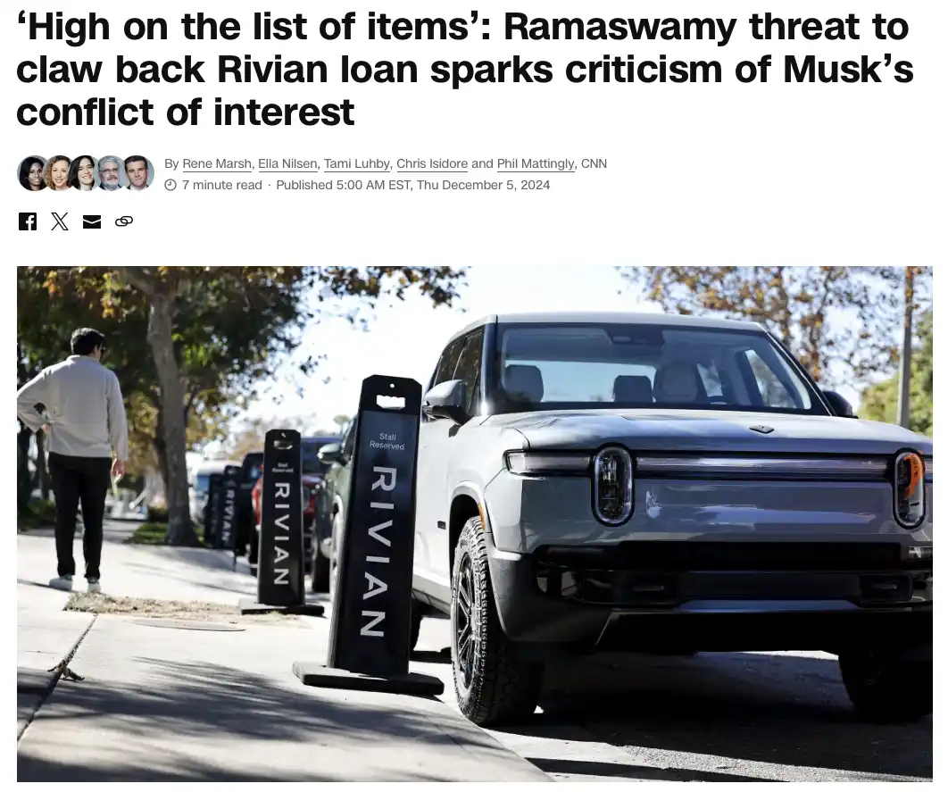 A white Rivian electric vehicle is parked in a reserved spot marked by a black 'RIVIAN' sign, while a man walks away on the…