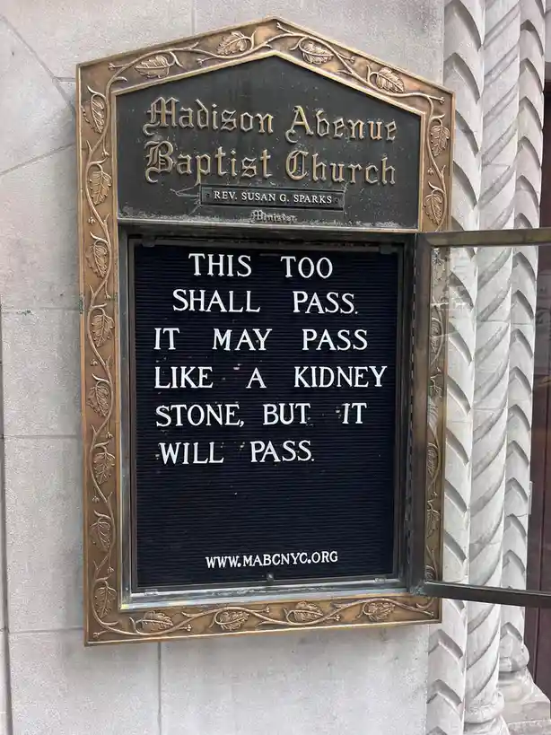 A photo of a church sign for Madison Avenue Baptist Church with a black letterboard displaying the text 'THIS TOO SHALL…